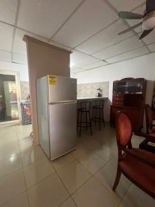 a kitchen with a refrigerator and a table with chairs at Pumila House in Villa Rosario