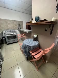 a kitchen with two chairs and a table and a stove at Pumila House in Villa Rosario +6 photos