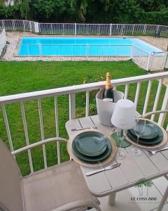 a table with a bottle of wine on a balcony at Le Cosy 888 Studio Plage 1 min Piscine Restaurants Casino in Les Trois-Îlets +16 photos