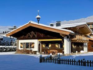 a house in the snow with a fence at Luxury Central Kirchberg in Kirchberg in Tirol