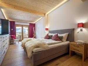 a bedroom with a large bed with a faux fur blanket at Luxury Central Kirchberg in Kirchberg in Tirol +32 photos