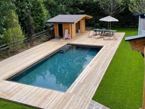 a swimming pool with a wooden deck and a cabin at Luxury Central Kirchberg in Kirchberg in Tirol
