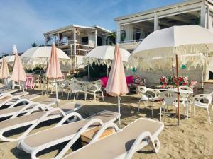 a bunch of chairs and umbrellas on a beach at Apartment Mirella in Umag