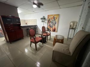 a waiting room with chairs and a painting of a zebra at Pumila House in Villa Rosario
