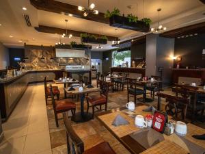 a restaurant with tables and chairs and a bar at Hotel Mirra San Luis in San Luis Río Colorado