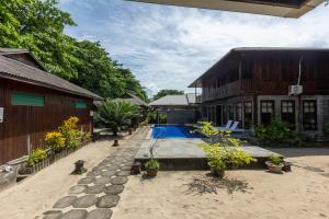 a house with a swimming pool next to a building at Bobocha Siladen Boutique Resort in Bunaken