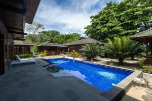 a swimming pool in front of a house at Bobocha Siladen Boutique Resort in Bunaken