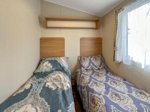 two beds in a small room with a window at Peppy in Newton Stewart
