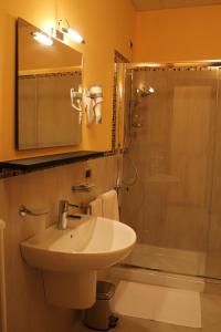 a bathroom with a sink and a shower at Hotel Padus Meublè Parma in San Quirico