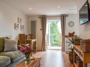 a living room with a couch and a table at Hillside Hideaway in Flaxley