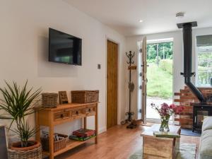 a living room with a tv on the wall at Hillside Hideaway in Flaxley