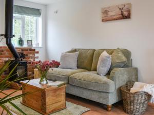 a living room with a couch and a table at Hillside Hideaway in Flaxley