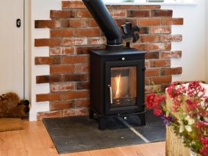 a fireplace in a living room with a brick wall at Hillside Hideaway in Flaxley +15 photos