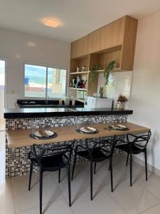 a kitchen with a wooden table and two chairs at Apto Mais Decor in Salinas +14 photos