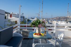 a table with a bowl of fruit on a balcony at Mykonos Town Aura Panorama with Private Terrace in Megali Ammos