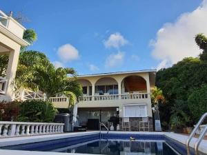 a house with a swimming pool in front of it at Penthouse Suite - Chez Mango Villa in Olveston