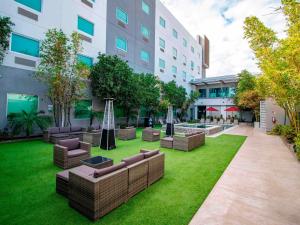 a courtyard in a building with furniture and grass at Hotel Mirra San Luis in San Luis Río Colorado