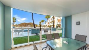 a balcony with a table and chairs and a view of the pool at Pool Delight - Ettalong Beach Resort in Ettalong Beach