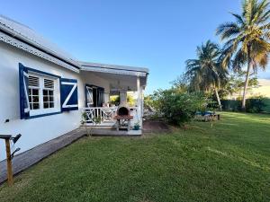 a white house with a porch and a yard at Villa Eli -6pers- piscine in Petit-Bourg