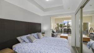 a bedroom with a large bed and a living room at Poolside Paradise Ettalong Beach Resort in Ettalong Beach