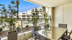 an apartment patio with a table and chairs and a view of the beach at Poolside Paradise Ettalong Beach Resort in Ettalong Beach +7 photos