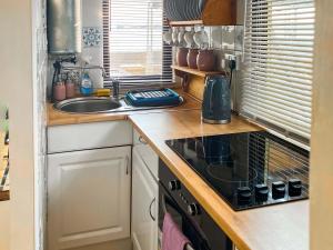 a kitchen with a stove top oven next to a sink at Angie's Beachside House in Saint Osyth