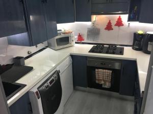 a small kitchen with a stove and a microwave at Habitaciones privadas in Madrid