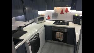 a small kitchen with a stove and a microwave at Habitaciones privadas in Madrid +8 photos