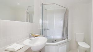 a bathroom with a sink and a shower and a toilet at Seashells - Ettalong Beach Resort in Ettalong Beach