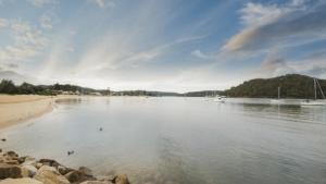 a view of a river with rocks and a beach at Seashells - Ettalong Beach Resort in Ettalong Beach