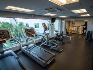 a gym with three treadmills and ellipticals in a room at Hotel Mirra San Luis in San Luis Río Colorado