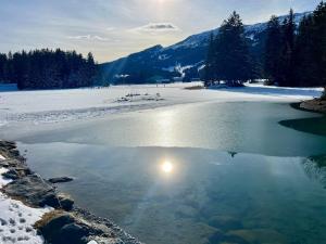 ein Gewässer, in dem sich die Sonne spiegelt in der Unterkunft Mountain Studio, Lenzerheide in Lenzerheide