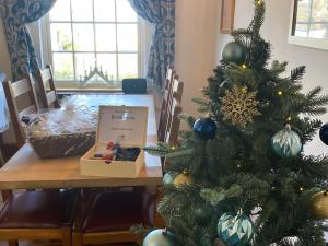 a christmas tree with a box on a table at The Boathouse in Appledore