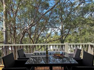 a table with a bottle of wine and a plate of food at Villa Remana in Pokolbin
