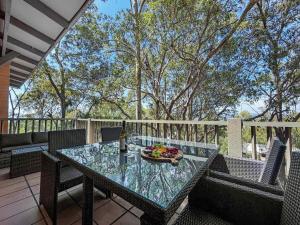 a glass table with a bowl of fruit on a patio at Villa Remana in Pokolbin +9 photos