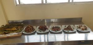 a group of plates of food on a counter at Lavanya Holiday Resort Kataragama in Kataragama +11 photos