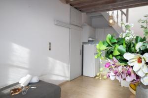 a kitchen with a refrigerator and flowers in a room at Mykonos Town Aura Panorama with Private Terrace in Megali Ammos +30 photos