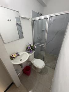 a bathroom with a shower and a toilet and a sink at Hotel Boutique Santa Ana in Cartago