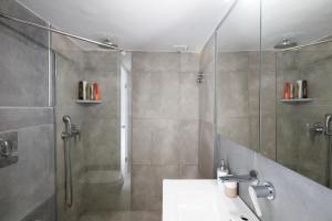 a bathroom with a shower and a sink at Mykonos Town Aura Panorama with Private Terrace in Megali Ammos