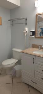 a white bathroom with a toilet and a sink at Champagne Island Resort Unit 107 in Wildwood