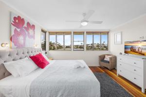 a bedroom with a large white bed and a window at Yulunga 20 in Mooloolaba +18 photos
