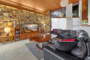 a living room with a couch and a table and a tv at Yulunga 20 in Mooloolaba