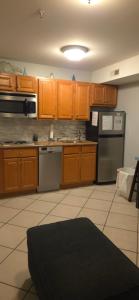 a kitchen with wooden cabinets and a black rug at Champagne Island Resort Unit 107 in Wildwood +5 photos