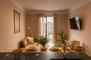 a kitchen and living room with a couch and a window at Villadhara Centro GDL in Guadalajara