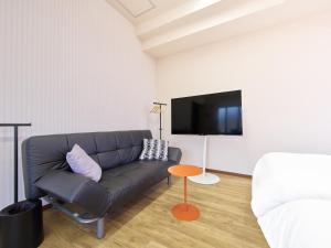 a living room with a couch and a flat screen tv at マーケットステイ新宮 in Shingū