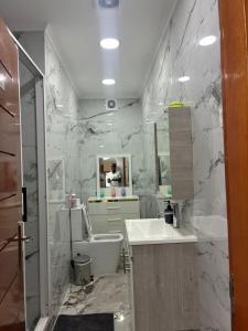 a bathroom with marble walls and a sink and a tub at vk-appart in Maianga