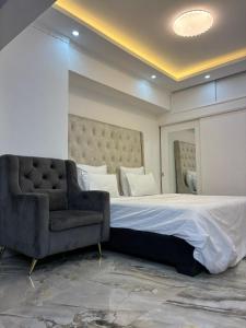 a bedroom with a large bed and a chair at vk-appart in Maianga