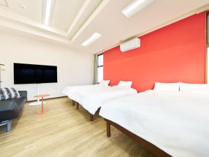 a room with three beds and a flat screen tv at マーケットステイ新宮 in Shingū
