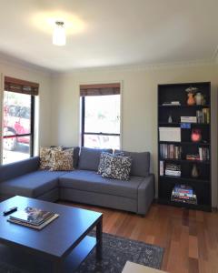 a living room with a blue couch and a coffee table at 2-Bedroom Townhouse Next to the Hospital in Bendigo