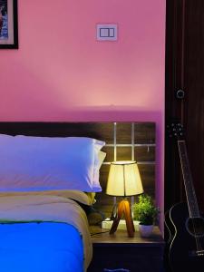 a bedroom with a bed and a lamp and a guitar at Aikara cottages in Vagamon